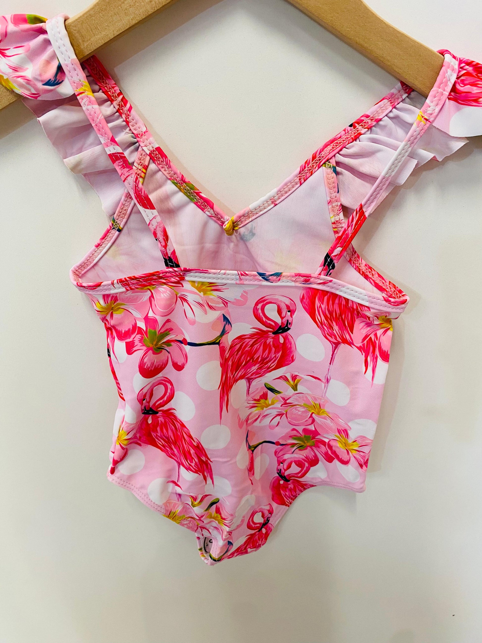 Pink flamingo-patterned swimsuit on a white background